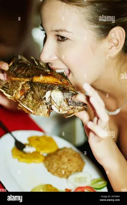 Женщина ест рыбу